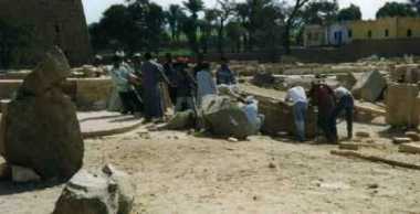 Workers manually haul a massive stone into place using ropes, just as workers from the Deir el Medina would have done in antiquity.